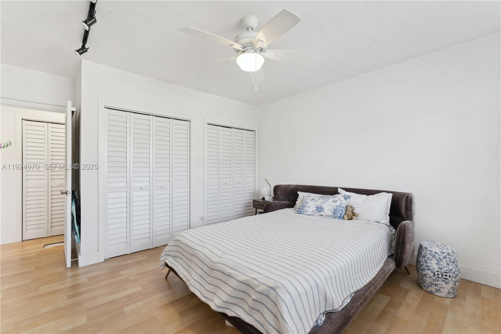 7440 Byron Avenue, Unit 1B Miami Beach, FL 33141 - Photo 12 of 16 a bedroom with a bed and a ceiling fan
