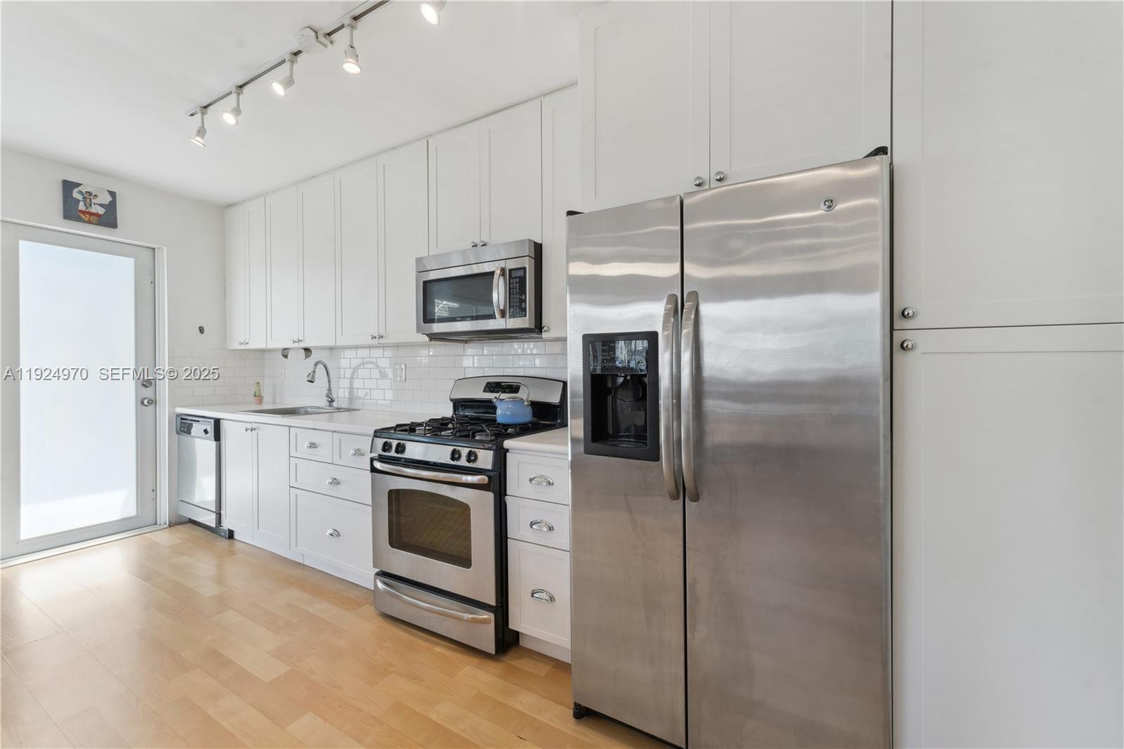 7440 Byron Avenue, Unit 1B Miami Beach, FL 33141 - Photo 6 of 16 a kitchen with a refrigerator sink and stove