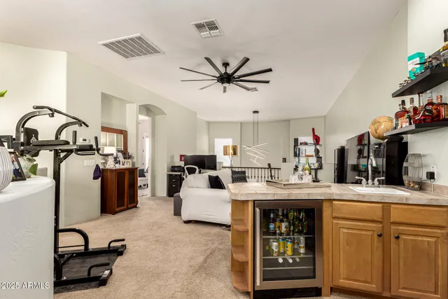 a living room with furniture a flat screen tv and kitchen view