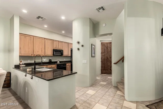 a kitchen with stainless steel appliances granite countertop a refrigerator a stove a sink and a microwave