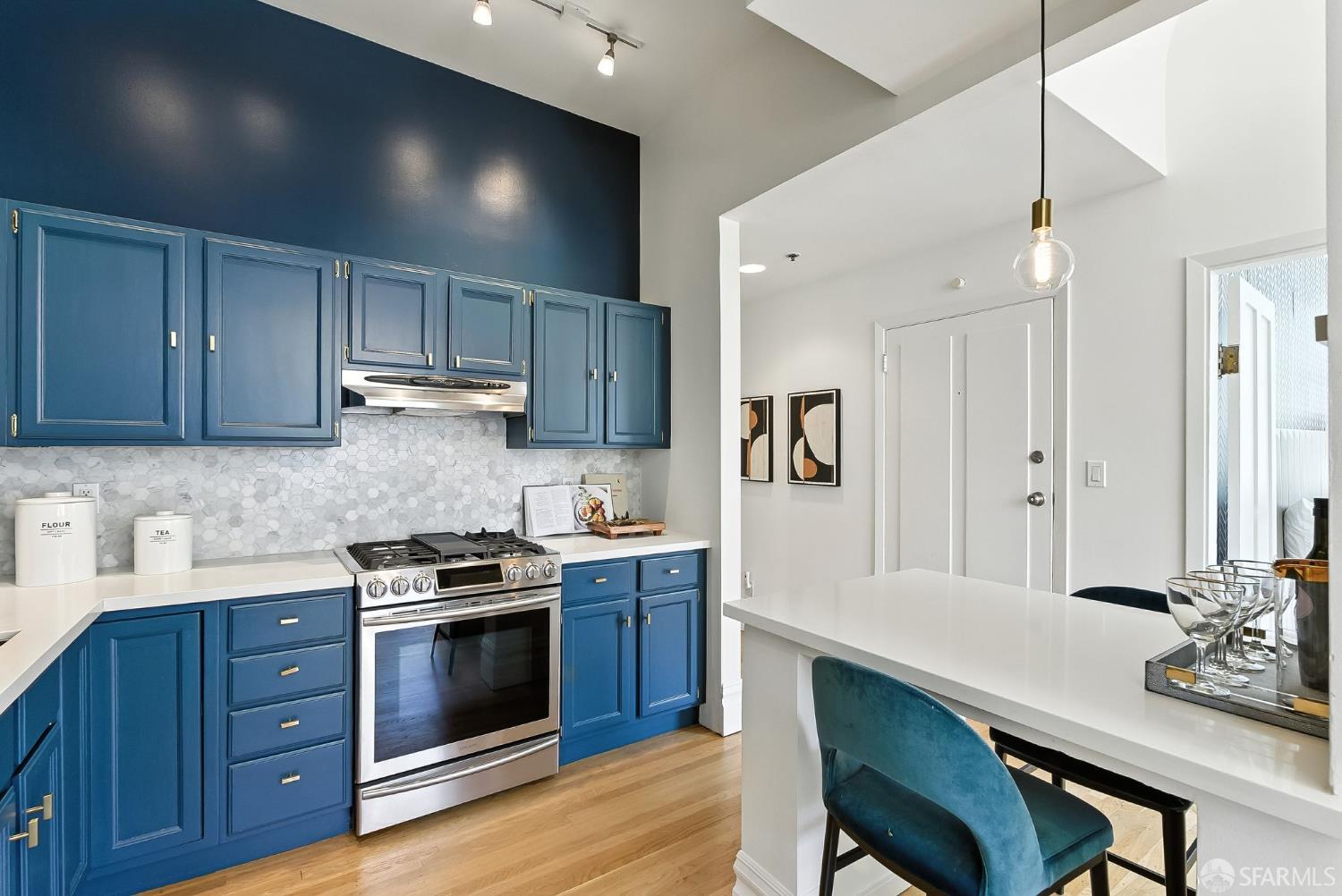 140 Divisadero Street, Unit 5 San Francisco, CA 94117 - Photo 12 of 32 a kitchen with stainless steel appliances a stove a sink cabinets and wooden floor