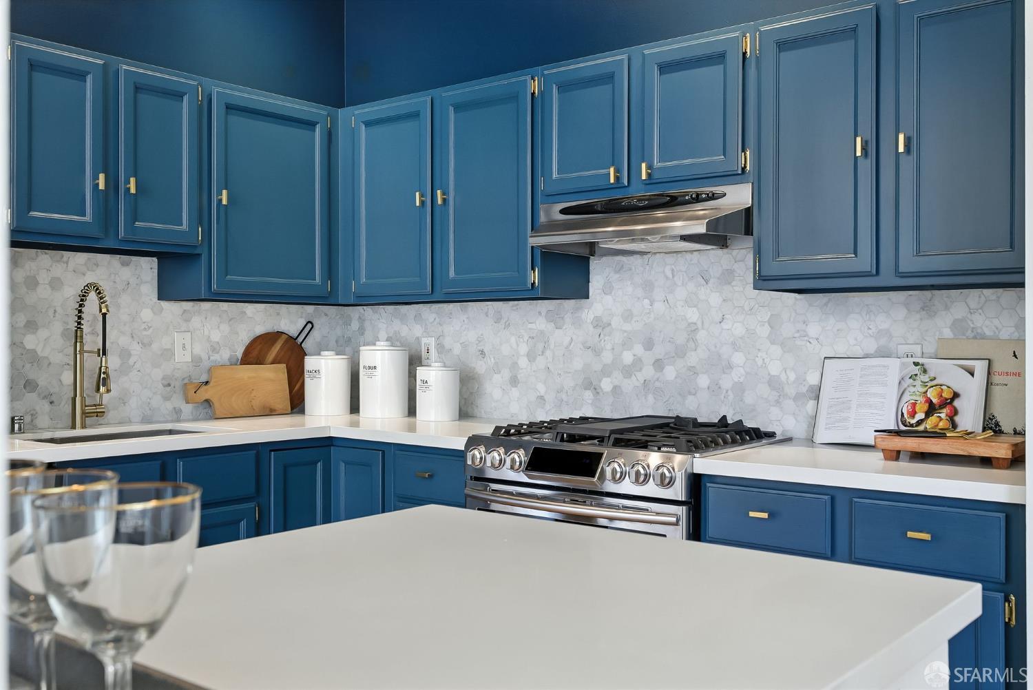 140 Divisadero Street, Unit 5 San Francisco, CA 94117 - Photo 14 of 32 a kitchen with stainless steel appliances a stove a sink cabinets and wooden floor