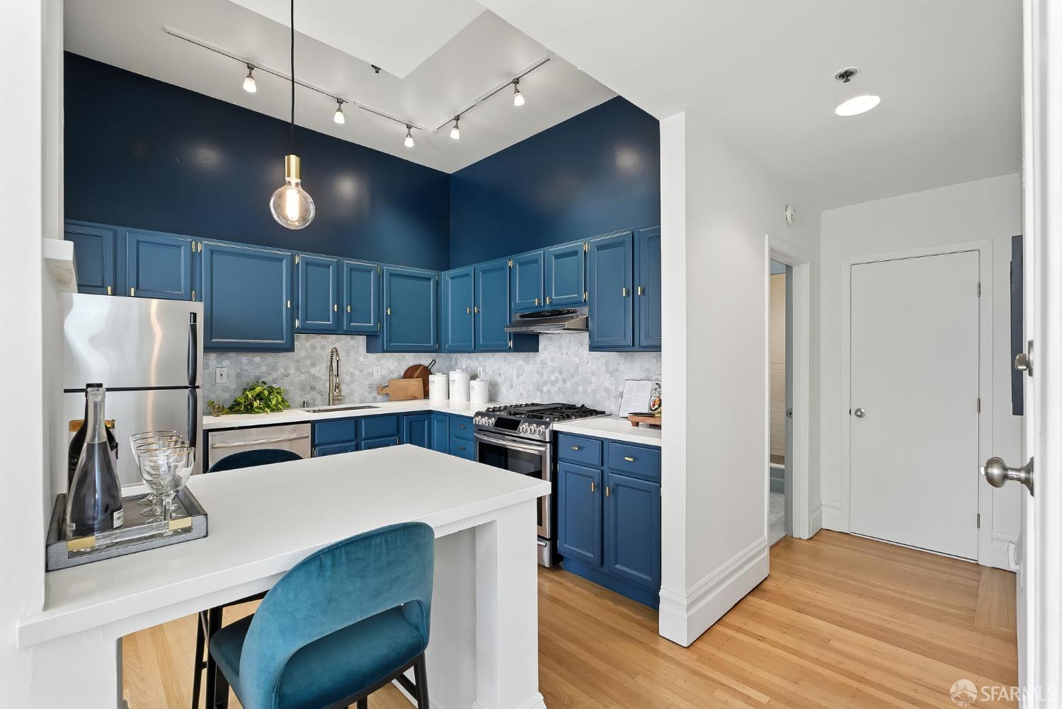 140 Divisadero Street, Unit 5 San Francisco, CA 94117 - Photo 10 of 32 a kitchen with a refrigerator a sink and wooden cabinets