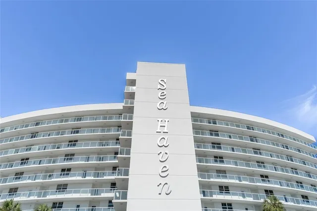 a front view of multi story residential apartment building with yard and green space