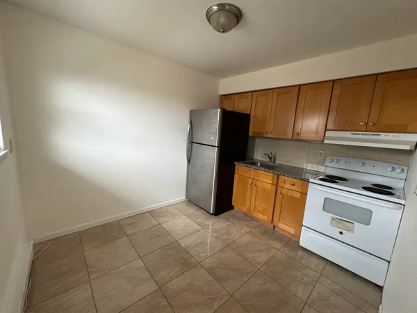a kitchen with a refrigerator a stove top oven a washer and dryer