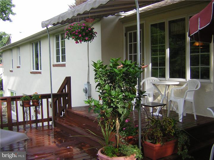3410 Lewis Road Newtown Square, PA 19073 - Photo 21 of 23 a view of a patio with table and chairs potted plants and floor to ceiling window