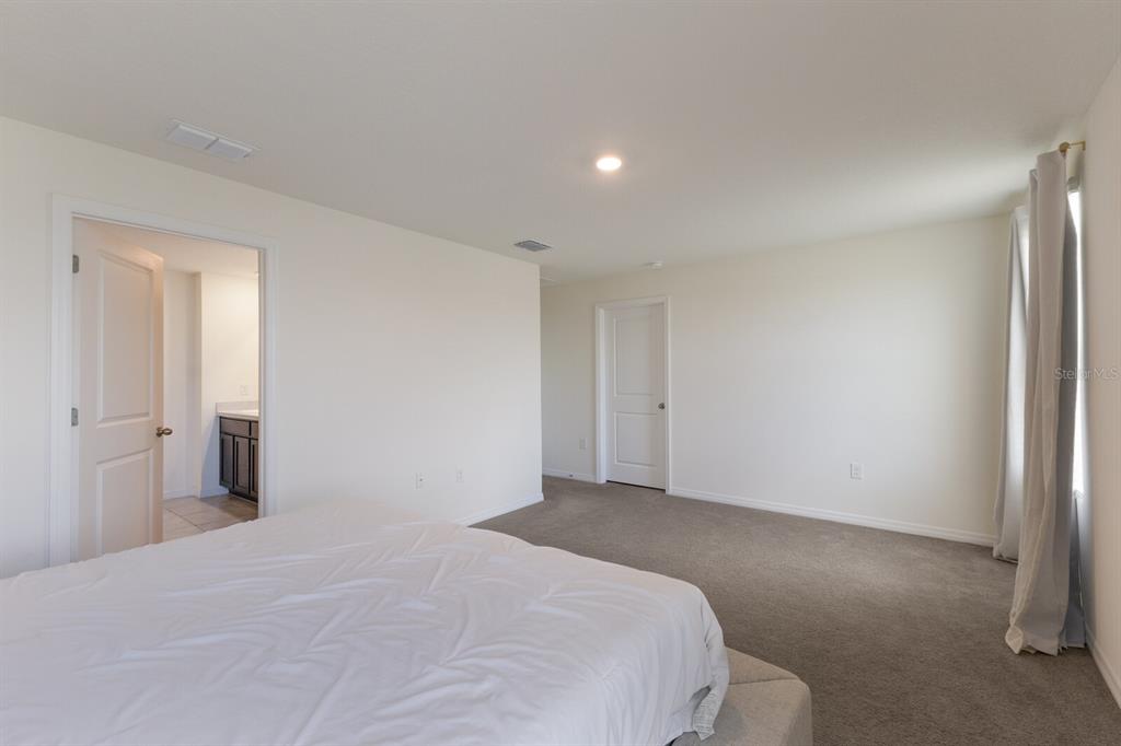 2938 Rock Sound Street Bradenton, FL 34208 - Photo 22 of 36 a bedroom with a bed and a mirror