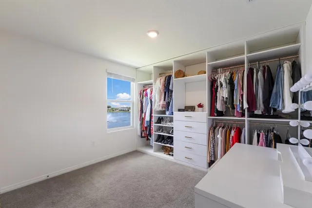 a view of walk in closet with clothes and shoes