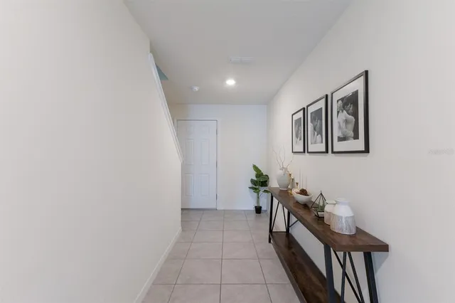 a hallway with chairs and frames on wall