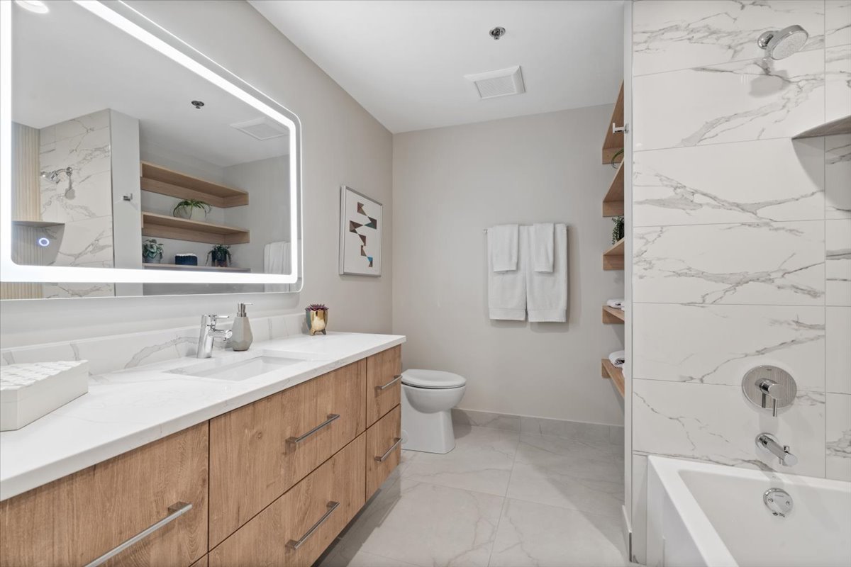 3951 North Wayne Avenue, Unit 308 Chicago, IL 60613 - Photo 18 of 22 a bathroom with a double vanity sink toilet and mirror
