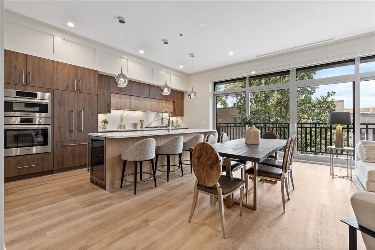 3951 North Wayne Avenue, Unit 308 Chicago, IL 60613 - Photo 4 of 22 a dining hall with stainless steel appliances kitchen island granite countertop a dining table and chairs with wooden floor