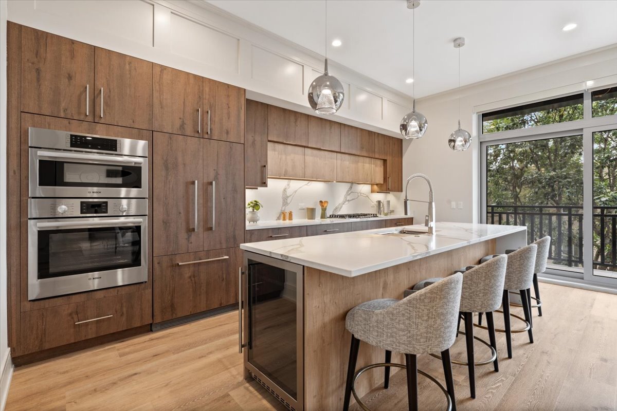 3951 North Wayne Avenue, Unit 308 Chicago, IL 60613 - Photo 7 of 22 a kitchen with stainless steel appliances kitchen island granite countertop a table chairs and a refrigerator