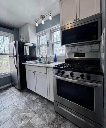 a kitchen with stainless steel appliances a refrigerator sink and cabinets