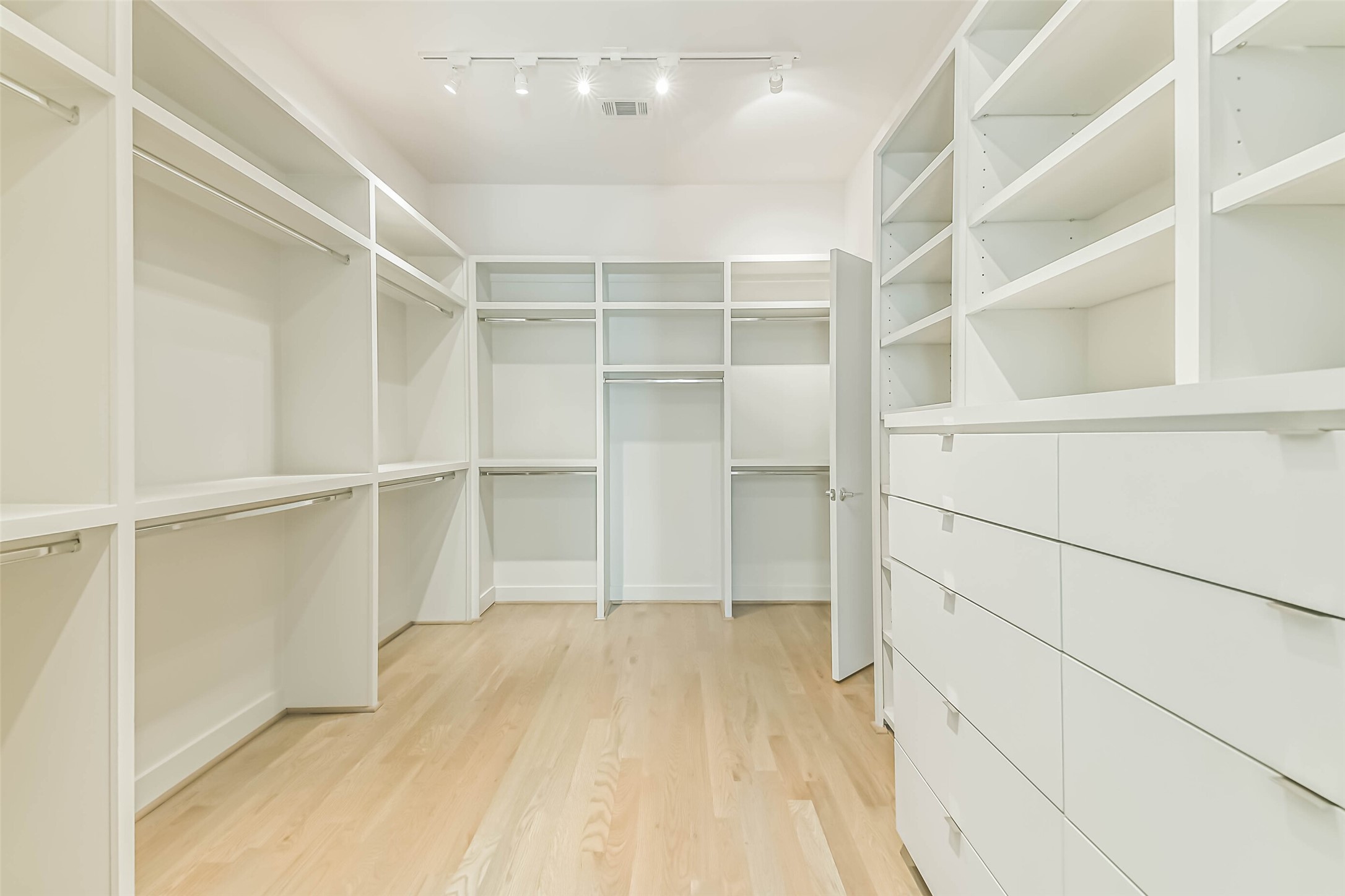 1509 Ruth Street Houston, TX 77004 - Photo 16 of 33 One of two Primary closets featuring custom built-ins to help stay organized. Custom lighting & hardwood floors highlight the space.
