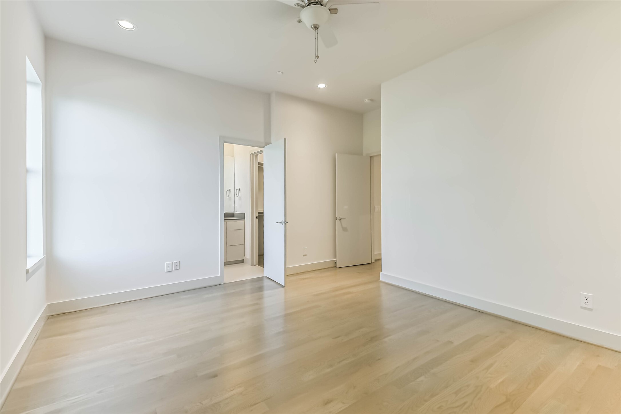 1509 Ruth Street Houston, TX 77004 - Photo 21 of 33 Secondary bedroom located opposite the primary suite, features recessed lighting, ceiling fan, hardwood floors and large window. Access to full bathroom and walk in closet make this an excellent guest suite or child's room.