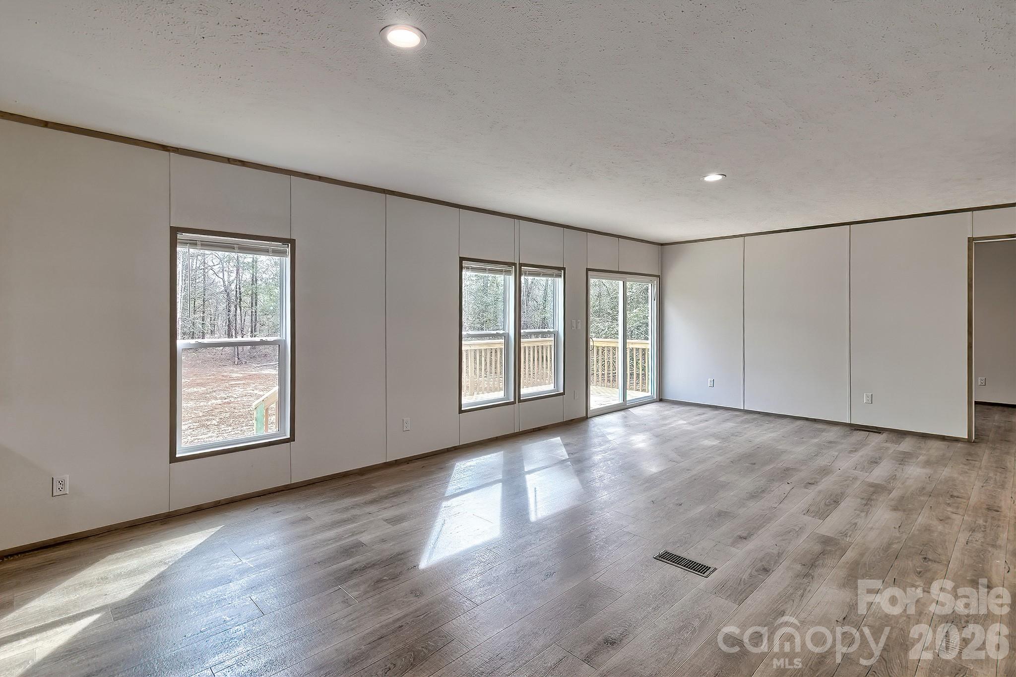 299 Ned Williams Road Kershaw, SC 29067 - Photo 31 of 43 an empty room with wooden floor and windows