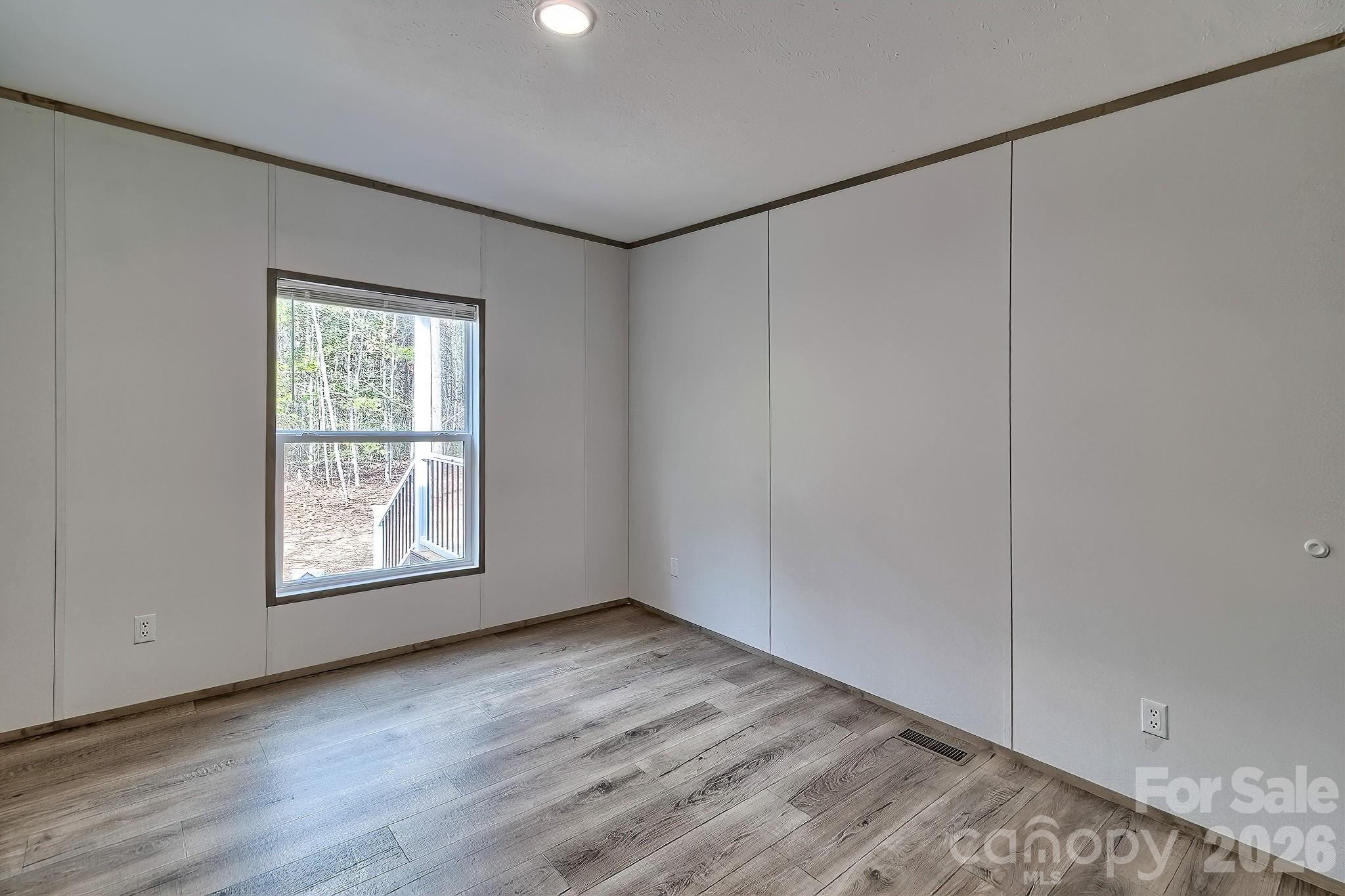 299 Ned Williams Road Kershaw, SC 29067 - Photo 42 of 43 an empty room with wooden floor and windows
