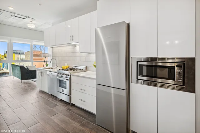 a kitchen with a refrigerator and a stove top oven