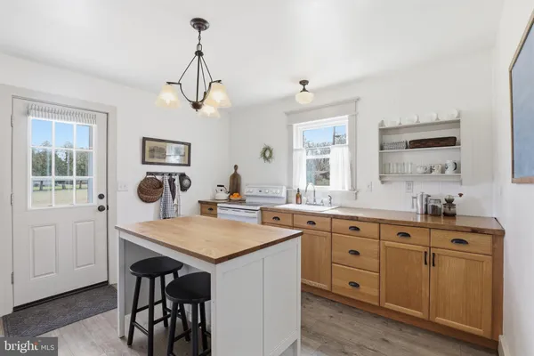 a kitchen with kitchen island a refrigerator stove and sink