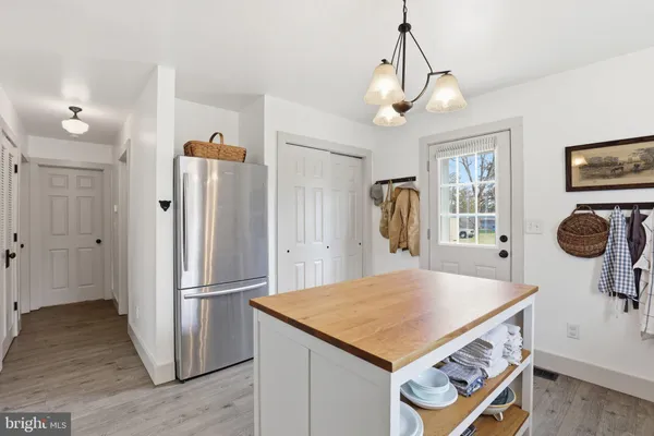 a kitchen that has a stove a table and chairs in it