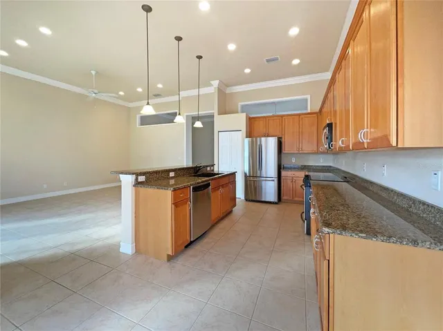 a large kitchen with kitchen island a large counter space a sink stainless steel appliances and cabinets