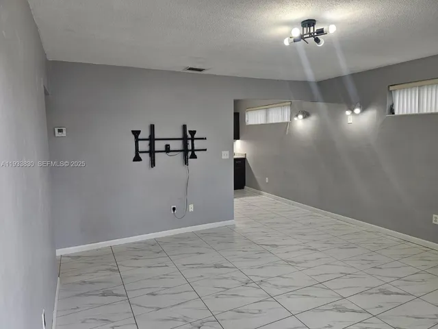 a view of a livingroom with a chandelier fan and window
