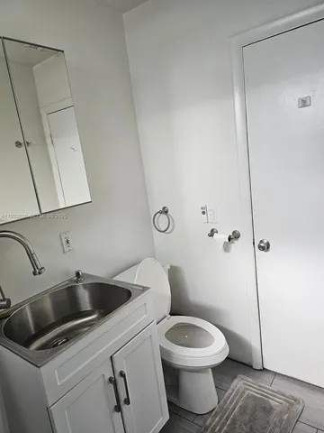 a bathroom with a toilet sink and mirror