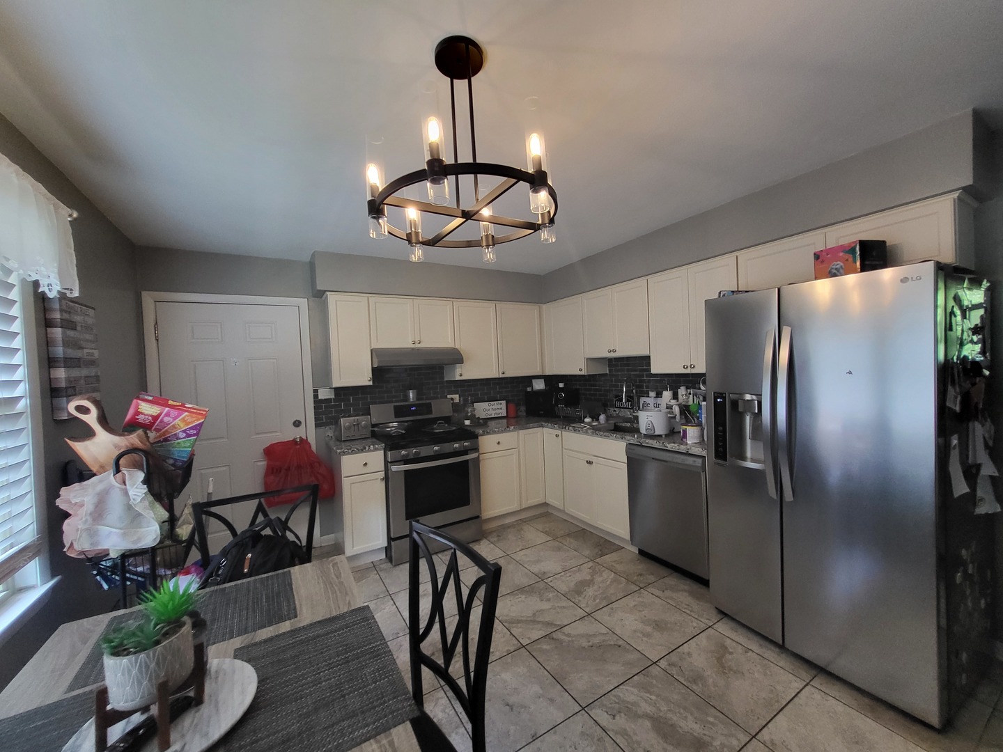 472 Northgate Court Riverside, IL 60546 - Photo 18 of 23 a kitchen with stainless steel appliances granite countertop a refrigerator a sink dishwasher a stove and a dining table with wooden floor