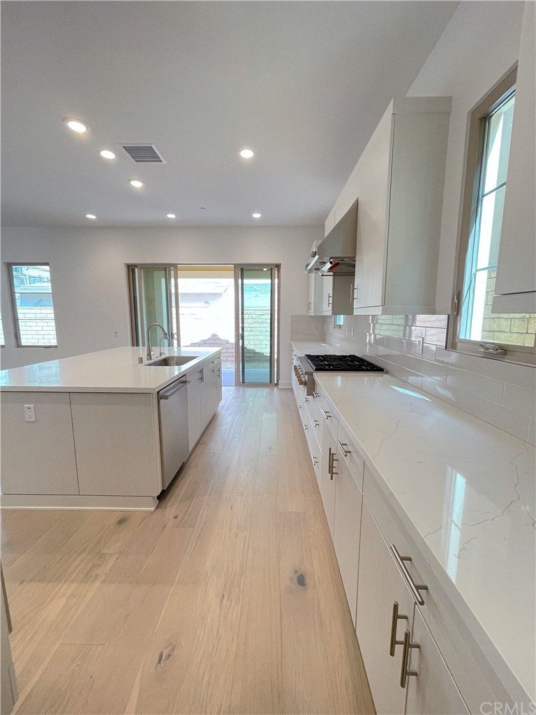215 Sutters Mill Irvine, CA 92602 - Photo 17 of 57 a large kitchen with stainless steel appliances granite countertop a sink and cabinets
