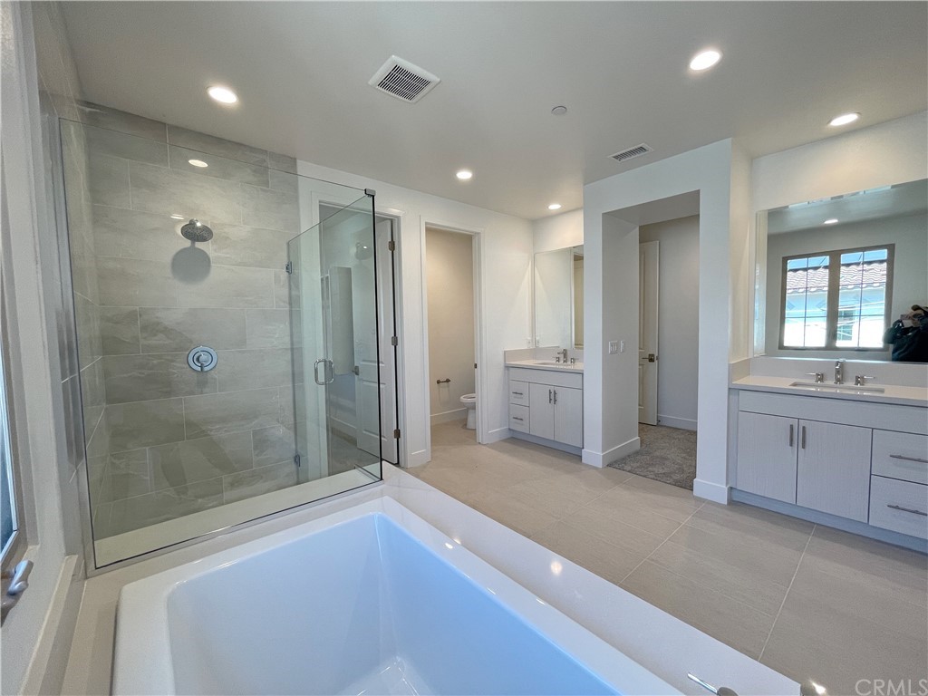 215 Sutters Mill Irvine, CA 92602 - Photo 36 of 57 a spacious bathroom with a mirror a shower and a sink