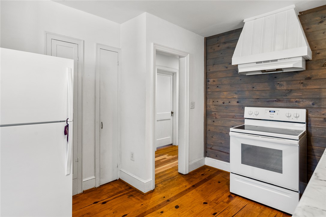 419 Whitehall Road Anderson, SC 29625 - Photo 13 of 28 Hearty wooden floors anchor this cooking area, complete with essential appliances and a charming wood-paneled accent wall.