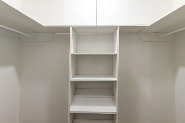 a view of walk in closet with empty racks