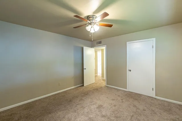 an empty room with fan and window