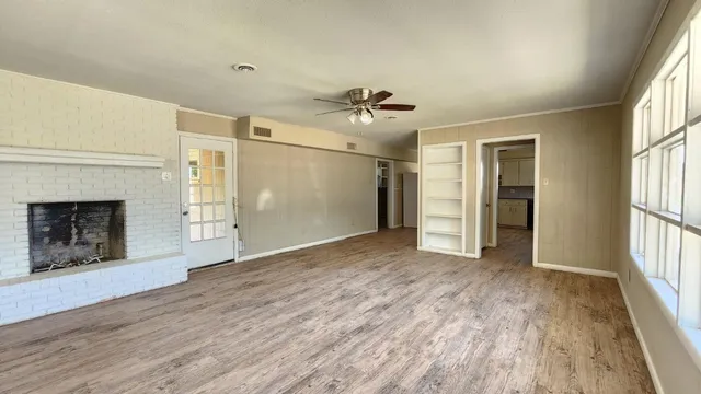 a view of an empty room with a fireplace and a window