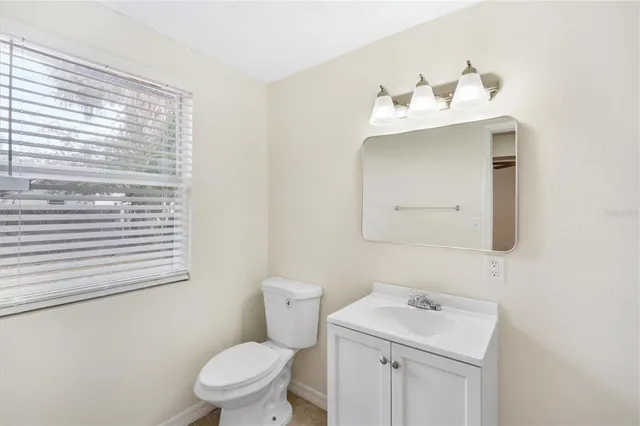 a bathroom with a sink vanity mirror and toilet