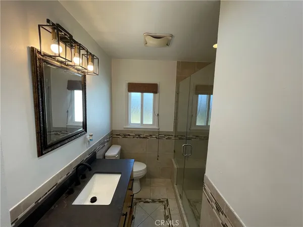 a bathroom with mirror bathtub and window