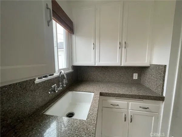 a bathroom with a granite countertop sink and cabinets