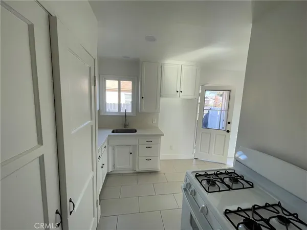 a kitchen with sink a stove and cabinets