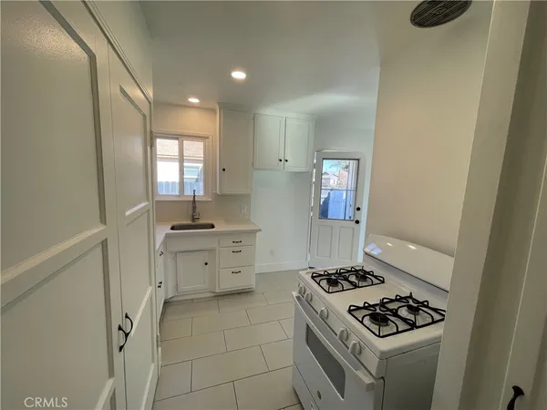 a kitchen with white cabinets and appliances