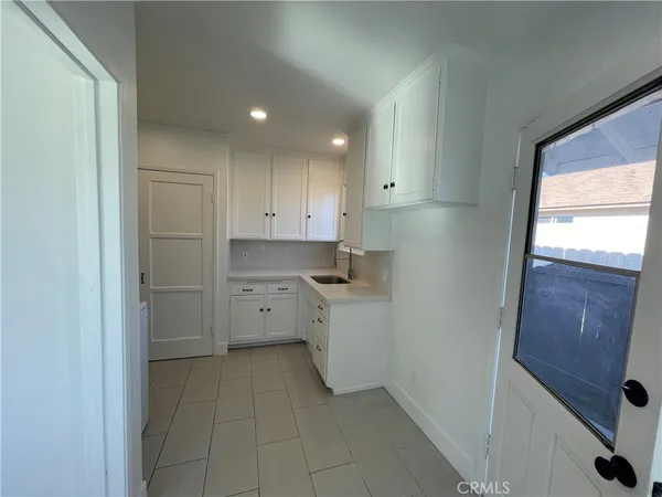 a kitchen with white cabinets and white appliances