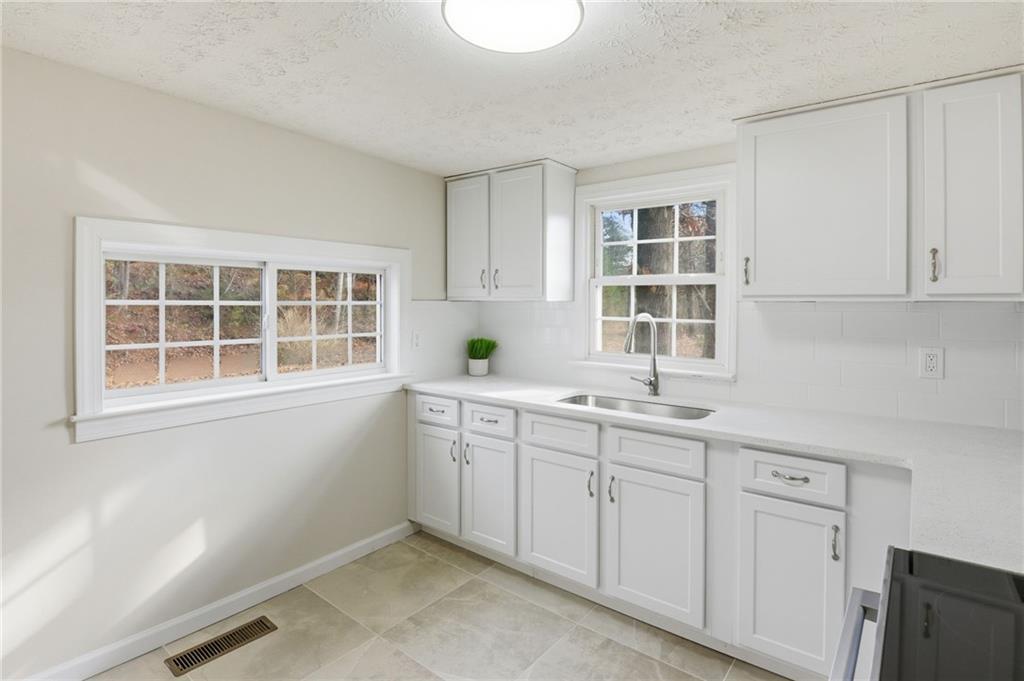1780 Wynn Lake Road Alto, GA 30510 - Photo 11 of 30 a kitchen with white cabinets and window