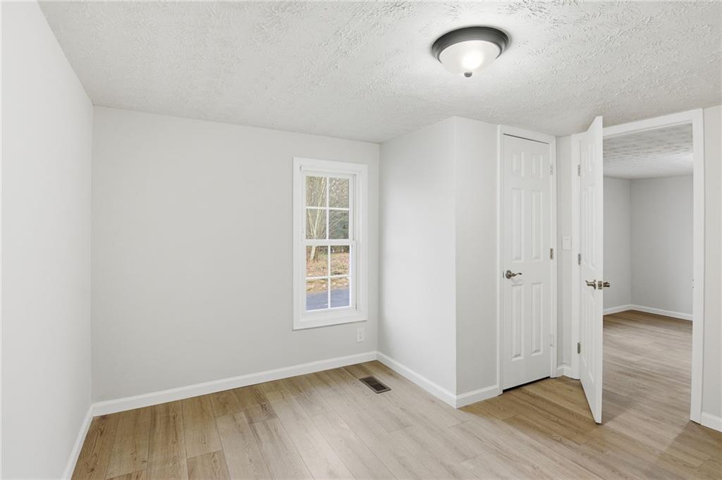 1780 Wynn Lake Road Alto, GA 30510 - Photo 19 of 30 an empty room with wooden floor and windows