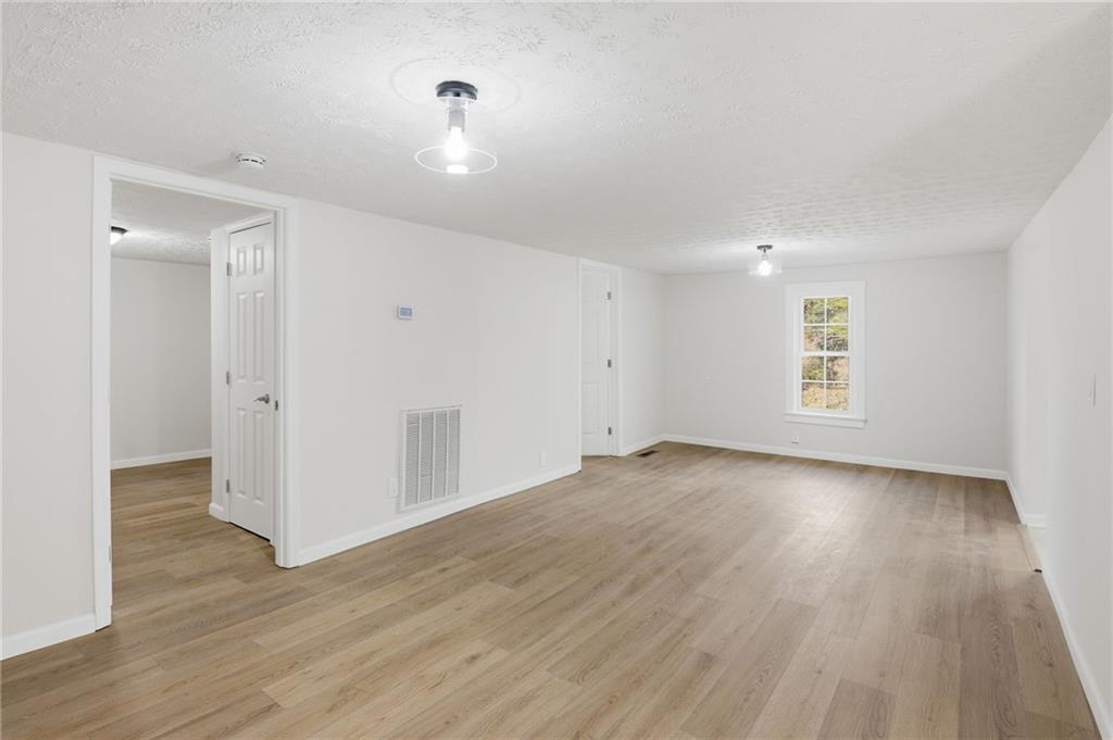 1780 Wynn Lake Road Alto, GA 30510 - Photo 7 of 30 an empty room with wooden floor and windows