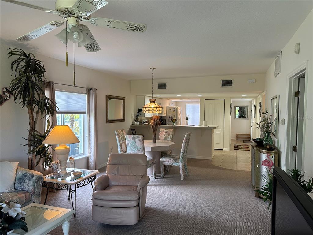 8050 Memory Lane, Unit 101 Rotonda West, FL 33947 - Photo 3 of 16 a living room with furniture a chandelier and a window