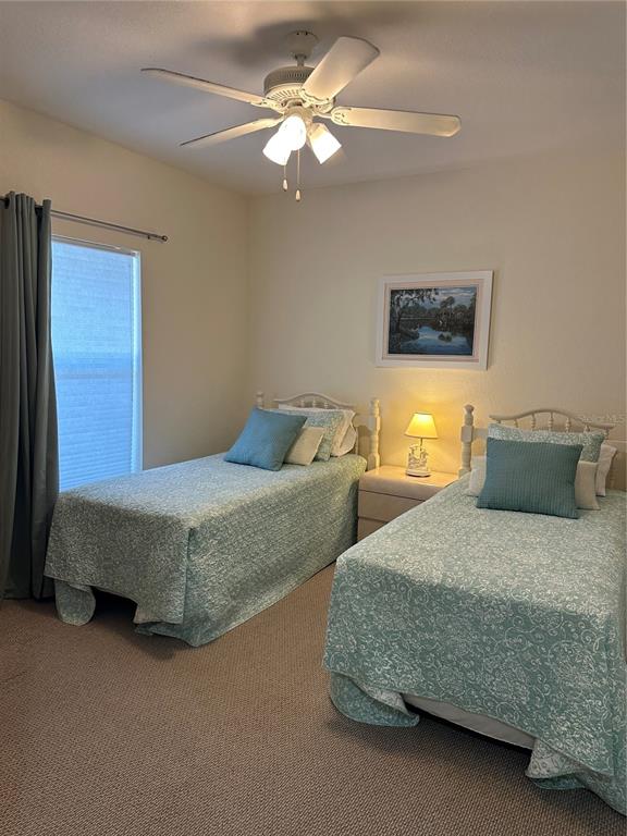 8050 Memory Lane, Unit 101 Rotonda West, FL 33947 - Photo 8 of 16 a bedroom with two separate beds and a chandelier