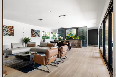 a living room with furniture floor to ceiling window and wooden floor