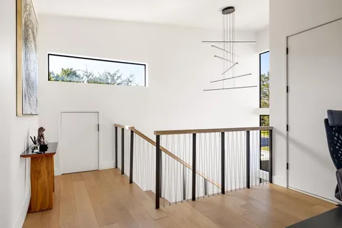 a view of hallway with a window and a chandelier