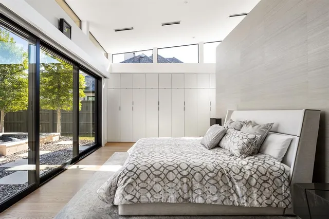 a bedroom with a large bed and large windows