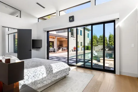 a bedroom with a large bed and large windows