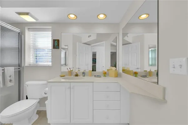 a bathroom with a double vanity sink toilet and a mirror